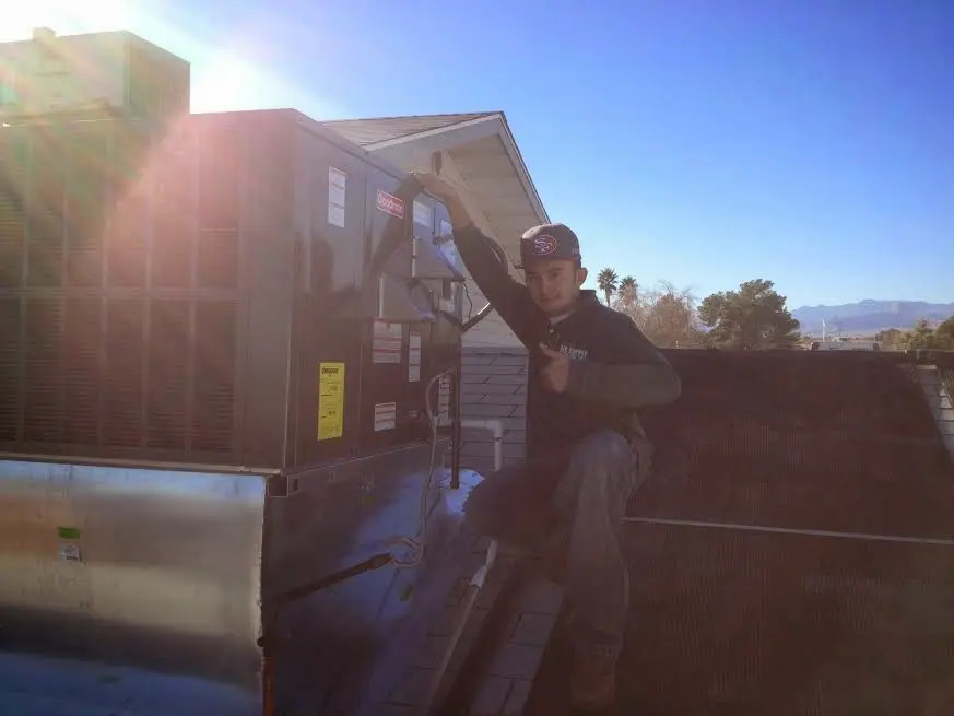 HVAC technician performing Heat Pump Repair on a rooftop unit in Montgomery